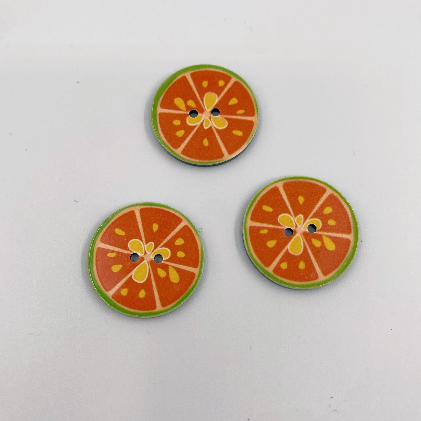 citrusknap i orange med to huller